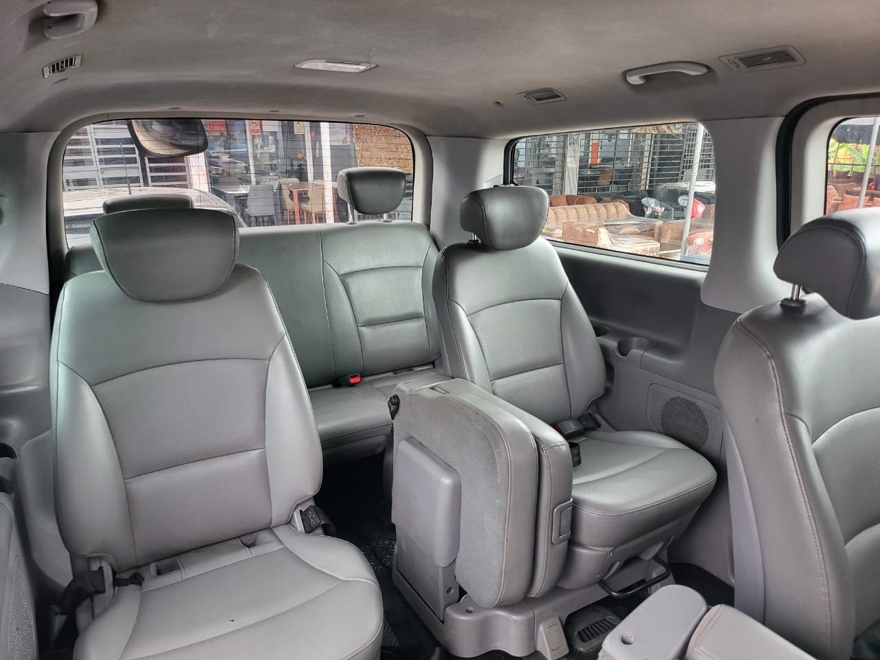 Intérieur du van Hyundai H-1 : sièges passagers en cuir gris sur plusieurs rangées